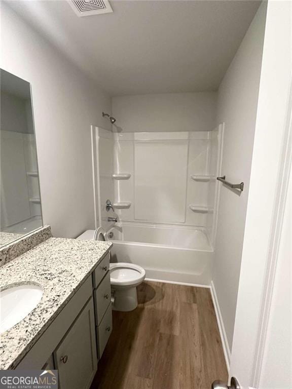 full bath featuring visible vents, toilet, wood finished floors, vanity, and shower / bathing tub combination