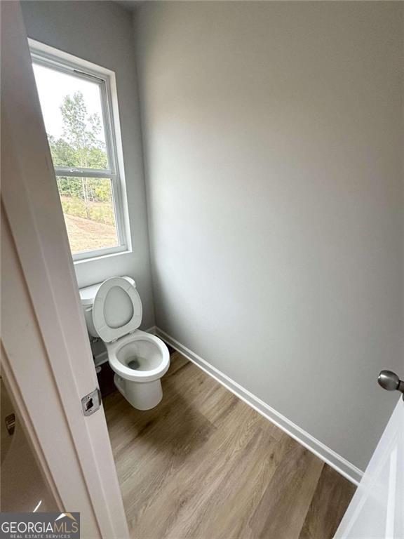 bathroom featuring toilet, baseboards, and wood finished floors