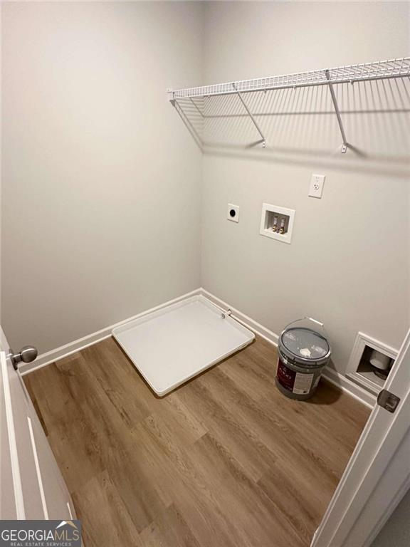 laundry room with hookup for an electric dryer, laundry area, washer hookup, wood finished floors, and baseboards