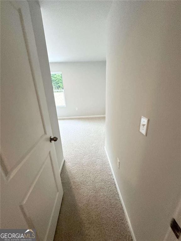 corridor with carpet and baseboards