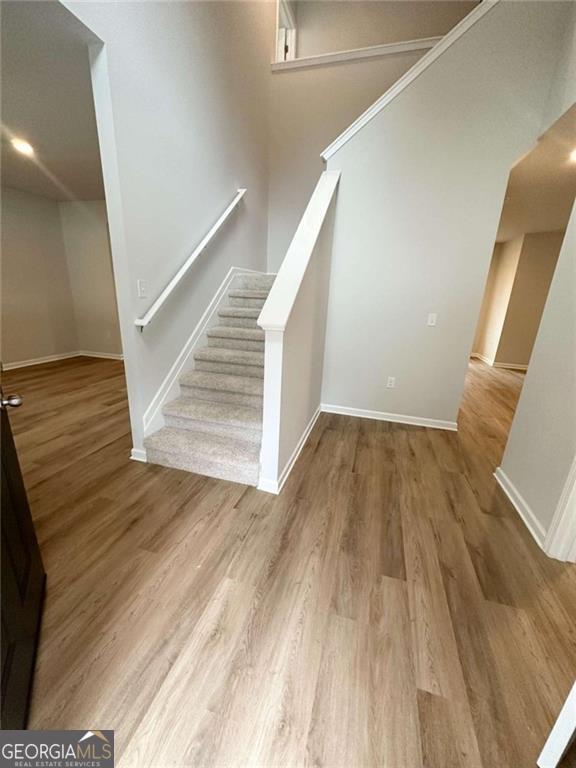 stairs featuring wood finished floors and baseboards