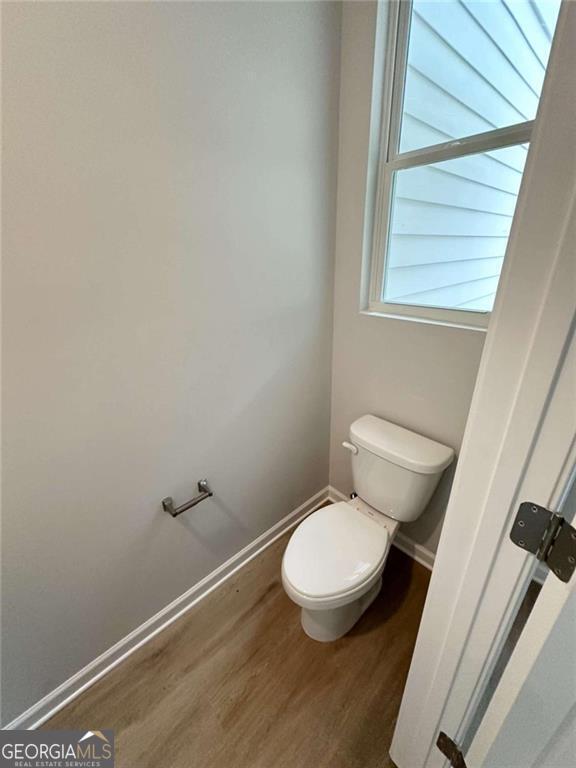 bathroom featuring wood finished floors, toilet, and baseboards