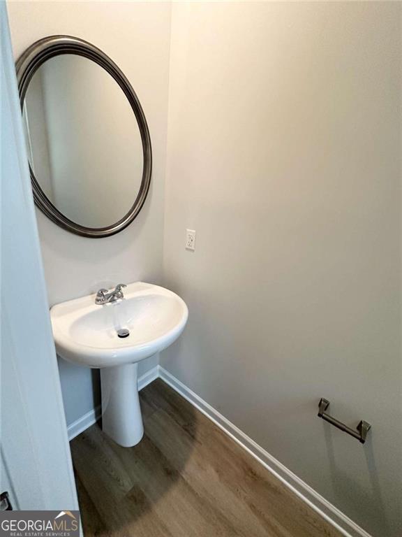 bathroom with baseboards and wood finished floors