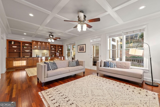 living area featuring dark wood-style flooring, ornamental molding, built in study area, coffered ceiling, and baseboards