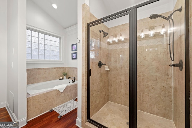 full bath with a bath, a shower stall, wood finished floors, and lofted ceiling