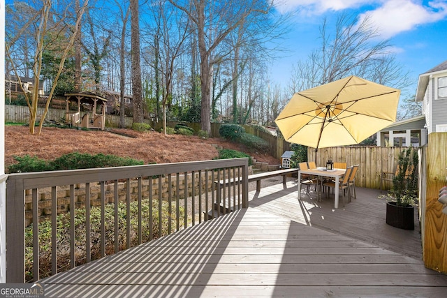 wooden deck featuring outdoor dining space and a fenced backyard