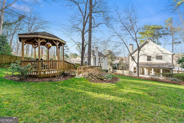 view of yard featuring fence, a deck, and a gazebo