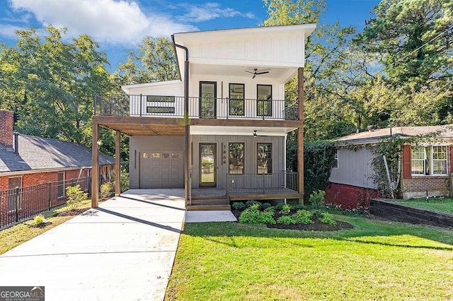 view of front facade featuring covered porch, concrete driveway, a front yard, a balcony, and a garage