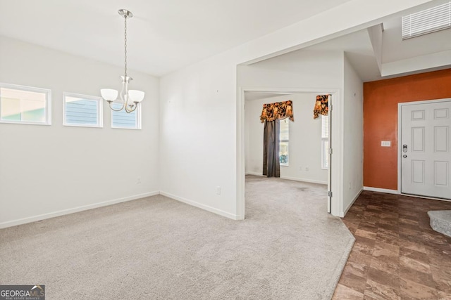 foyer with carpet, baseboards, visible vents, and a chandelier