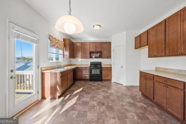 kitchen with baseboards, light countertops, black appliances, brown cabinetry, and decorative light fixtures