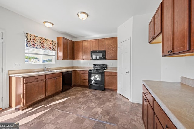 kitchen with brown cabinetry, light countertops, a sink, and black appliances