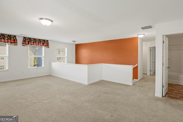 spare room featuring baseboards, visible vents, and carpet flooring