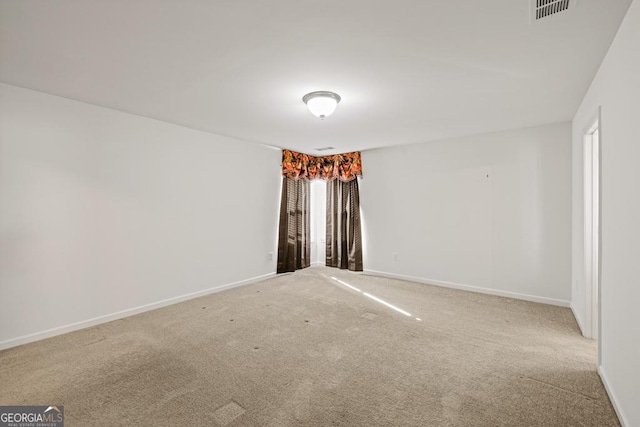 carpeted empty room featuring baseboards and visible vents