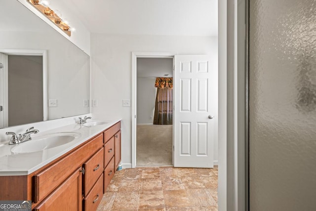 full bath featuring baseboards, double vanity, a sink, and stone finish flooring