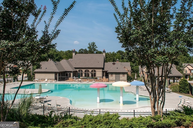 community pool featuring a patio and fence