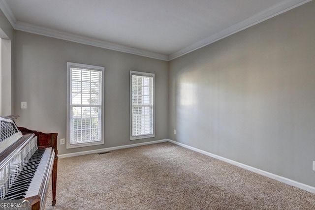 unfurnished room featuring baseboards, crown molding, visible vents, and carpet flooring