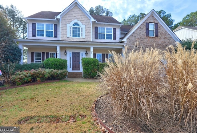 view of front of house with a front lawn and brick siding