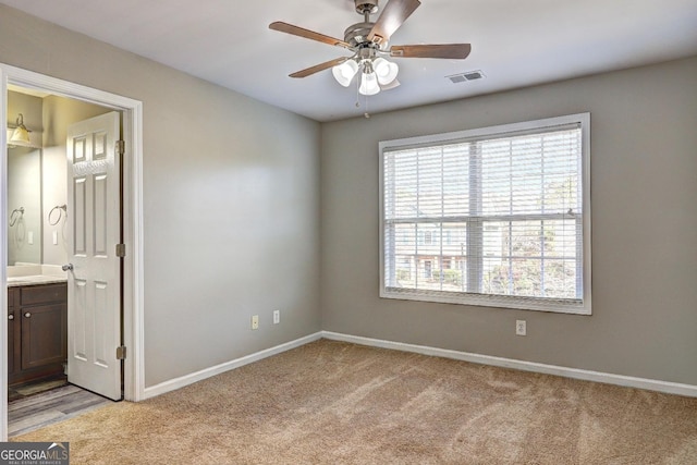 unfurnished room featuring light carpet, baseboards, visible vents, and a ceiling fan