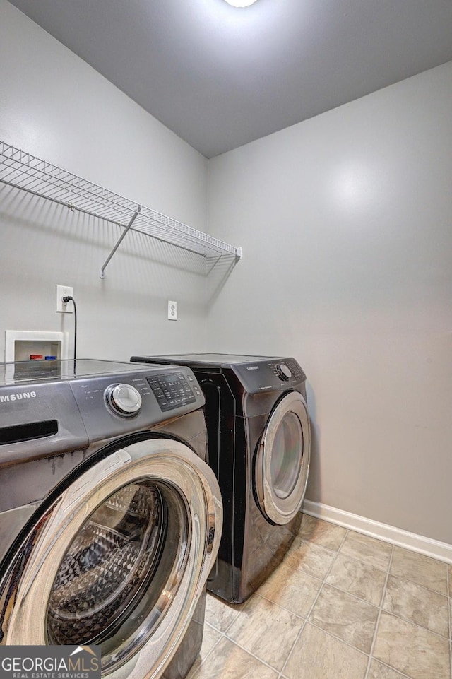 laundry area featuring laundry area, washing machine and dryer, and baseboards