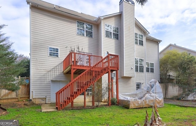 back of property with a yard, a chimney, stairway, fence, and a wooden deck