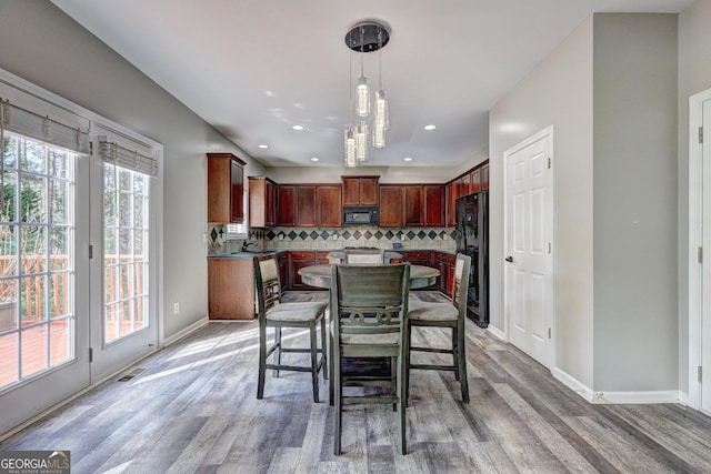 dining room with light wood finished floors, recessed lighting, and baseboards