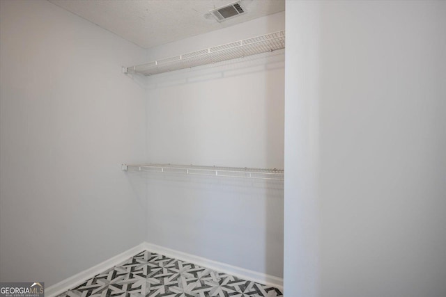 walk in closet with visible vents and tile patterned floors