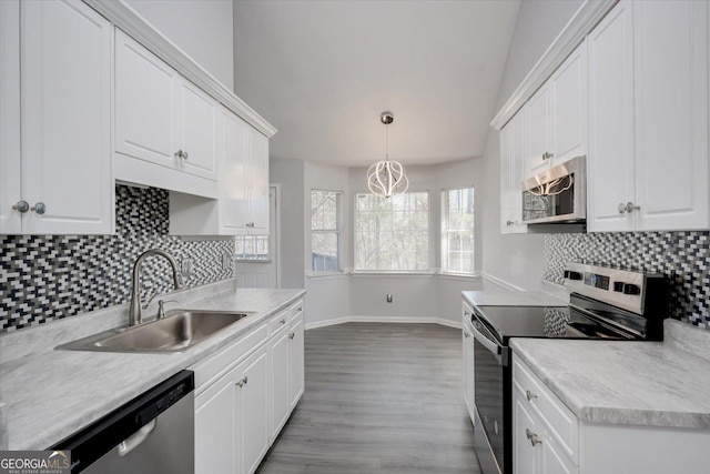 kitchen with appliances with stainless steel finishes, white cabinets, a sink, and light countertops