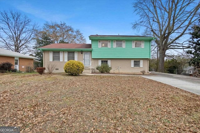 tri-level home with crawl space, driveway, and brick siding