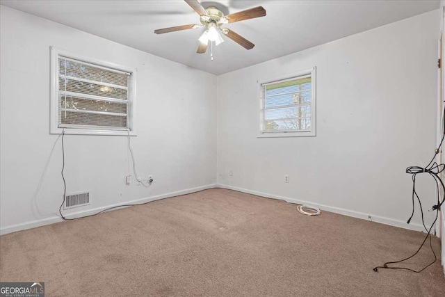 carpeted empty room featuring visible vents, ceiling fan, and baseboards