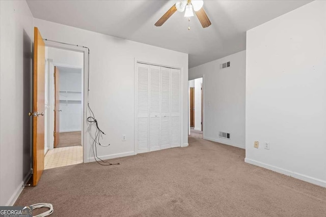 unfurnished bedroom featuring carpet floors, baseboards, visible vents, and a closet