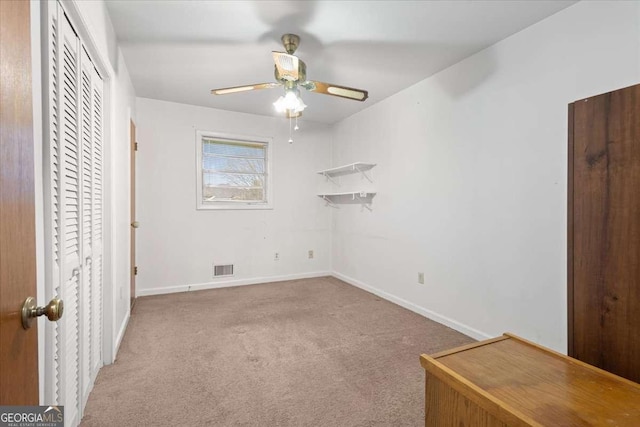 unfurnished bedroom featuring carpet, a closet, visible vents, ceiling fan, and baseboards