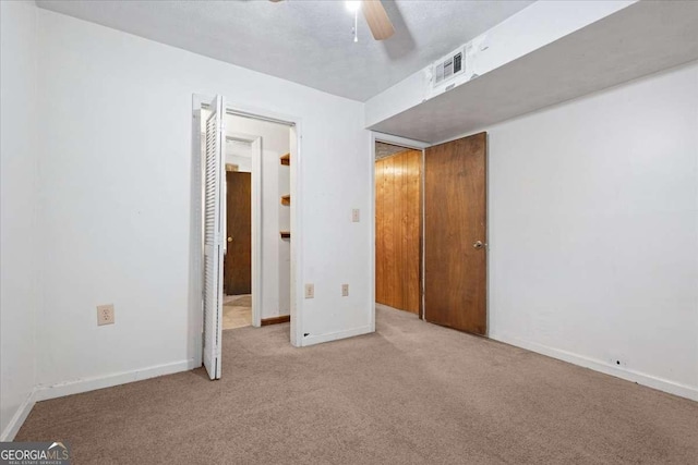 unfurnished bedroom with carpet, visible vents, ceiling fan, and baseboards