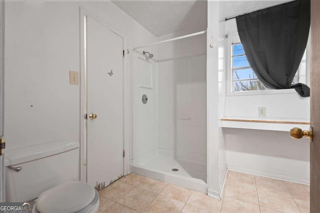 full bathroom with tile patterned flooring, toilet, a shower stall, and a textured ceiling