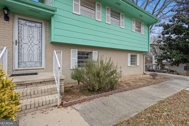 doorway to property featuring brick siding