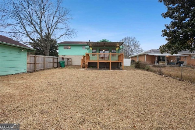 rear view of property featuring a fenced backyard and a wooden deck