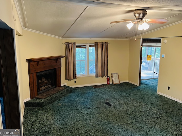 unfurnished living room with vaulted ceiling, a fireplace with raised hearth, dark carpet, and plenty of natural light