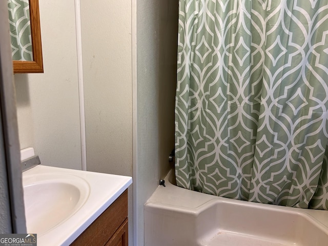 full bath featuring a textured wall, vanity, and shower / bathtub combination with curtain