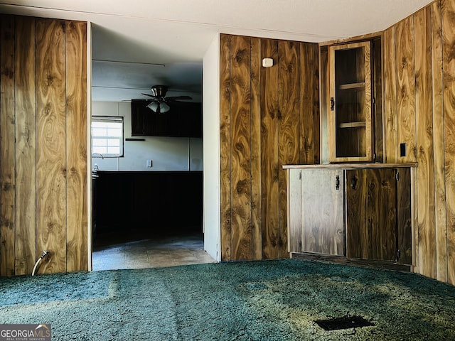 spare room with a ceiling fan and wooden walls