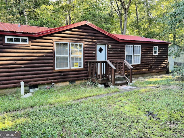 log-style house featuring metal roof and crawl space