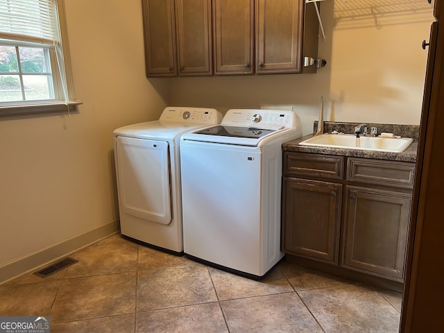 laundry room with cabinet space, visible vents, washing machine and dryer, light tile patterned flooring, and a sink