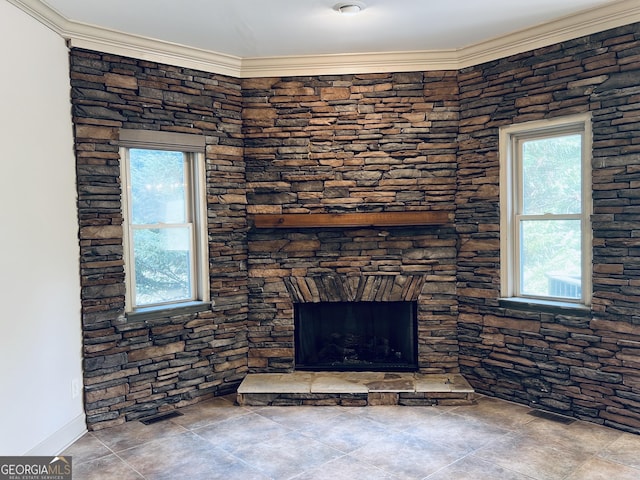 living room featuring a stone fireplace, visible vents, and crown molding