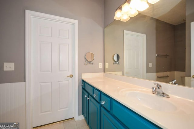 bathroom featuring tile patterned flooring, a notable chandelier, and vanity