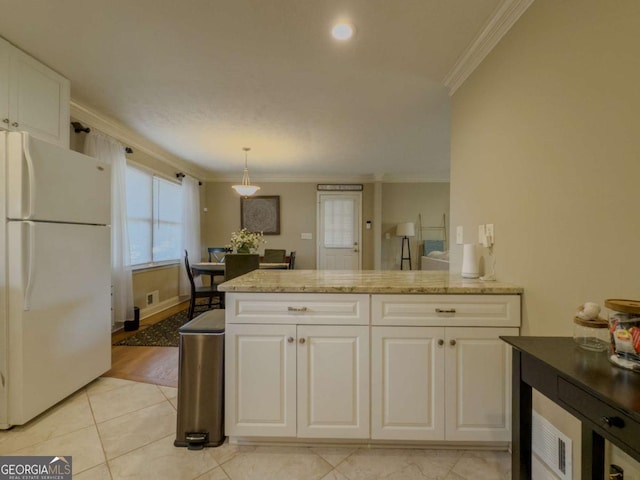 kitchen with freestanding refrigerator, white cabinets, and crown molding