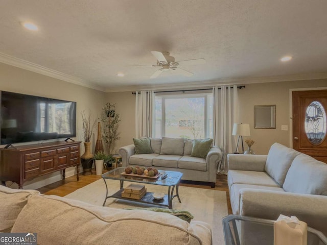 living room featuring plenty of natural light, ornamental molding, and wood finished floors