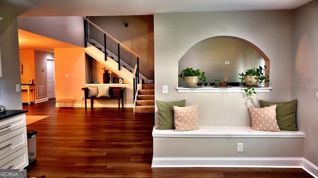 interior space featuring baseboards, stairway, and wood finished floors