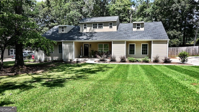 cape cod home featuring a front lawn, roof with shingles, and fence