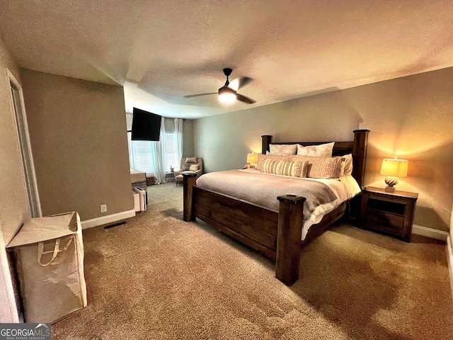 carpeted bedroom with a ceiling fan, visible vents, a textured ceiling, and baseboards