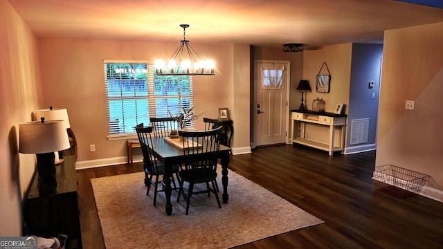 dining room with dark wood-type flooring, visible vents, baseboards, and an inviting chandelier