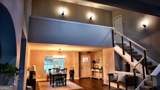 dining area featuring baseboards, a notable chandelier, stairway, and wood finished floors