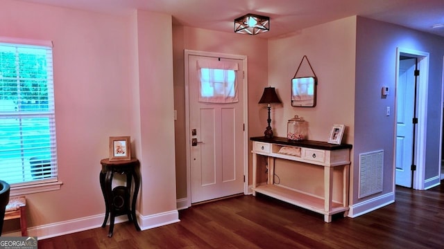 foyer with visible vents, dark wood finished floors, and baseboards